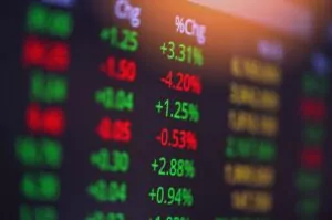 A photo of a screen showing stock market returns in green and red fonts.