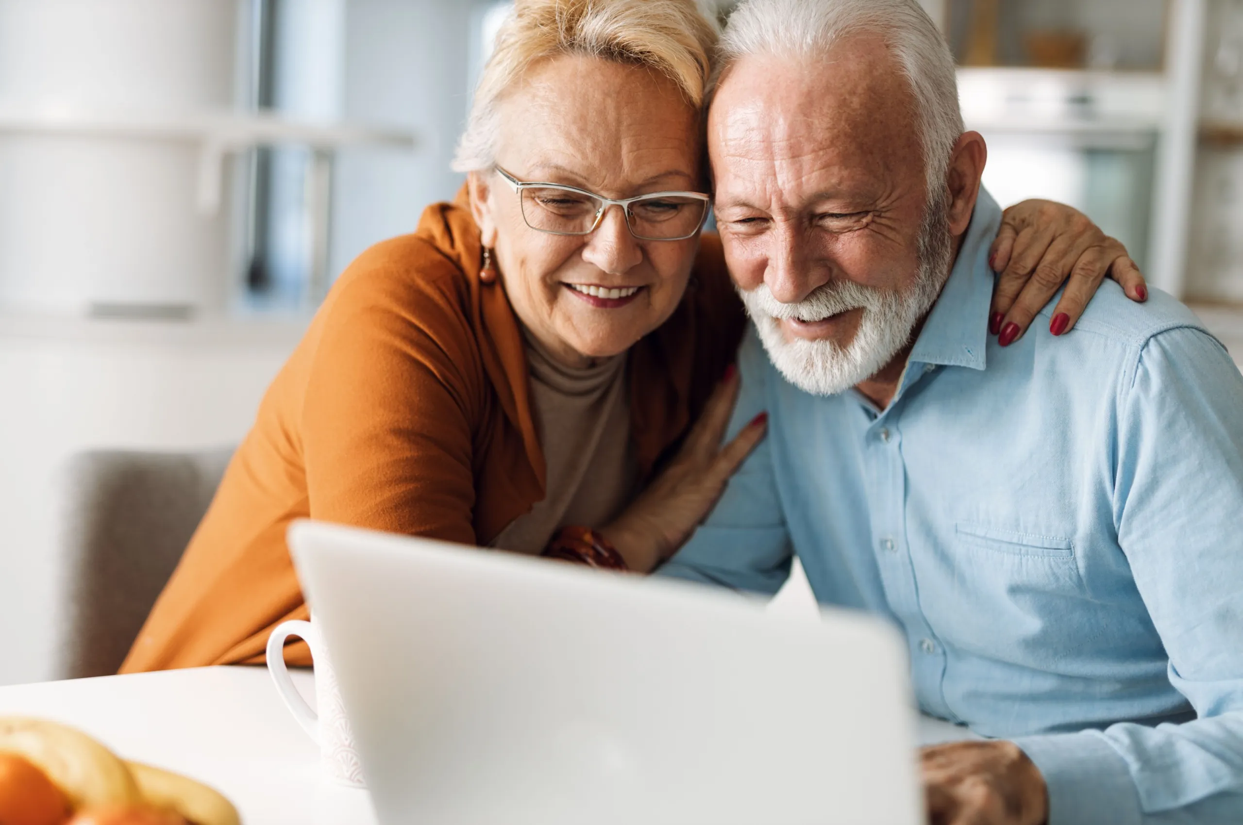A happy senior couple looking at a computer.